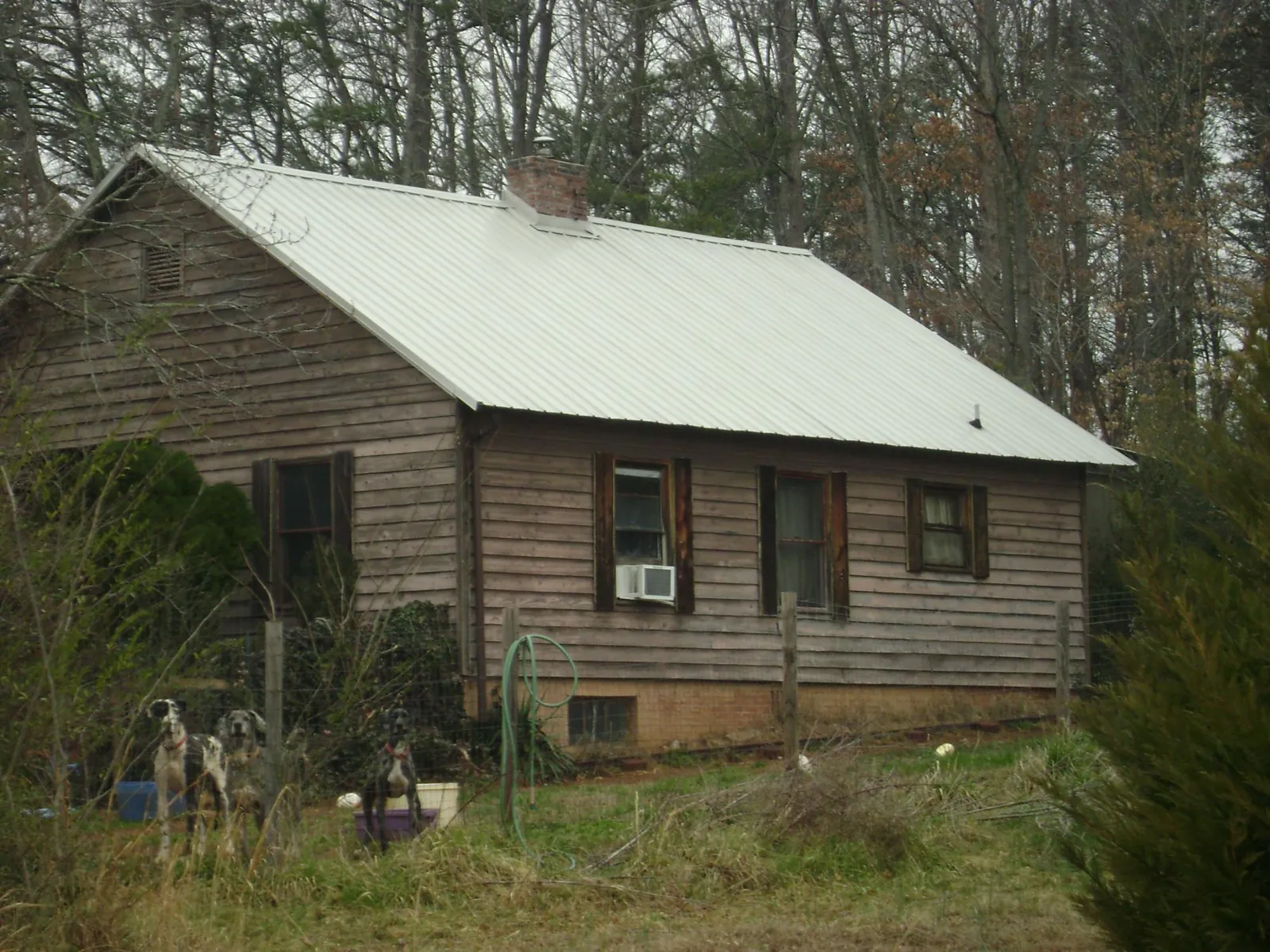 White metal roof on an old wood sided farmhouse, from a Metal Roof Installation job in Bethesda